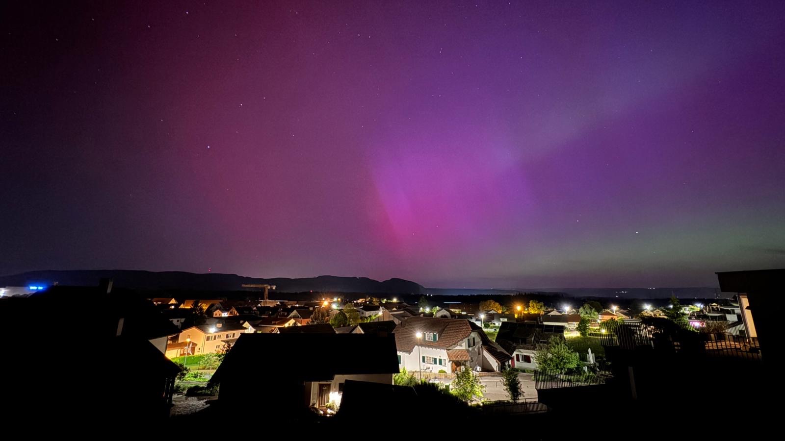 Polarlichter über einem nächtlichen Wohnquartier