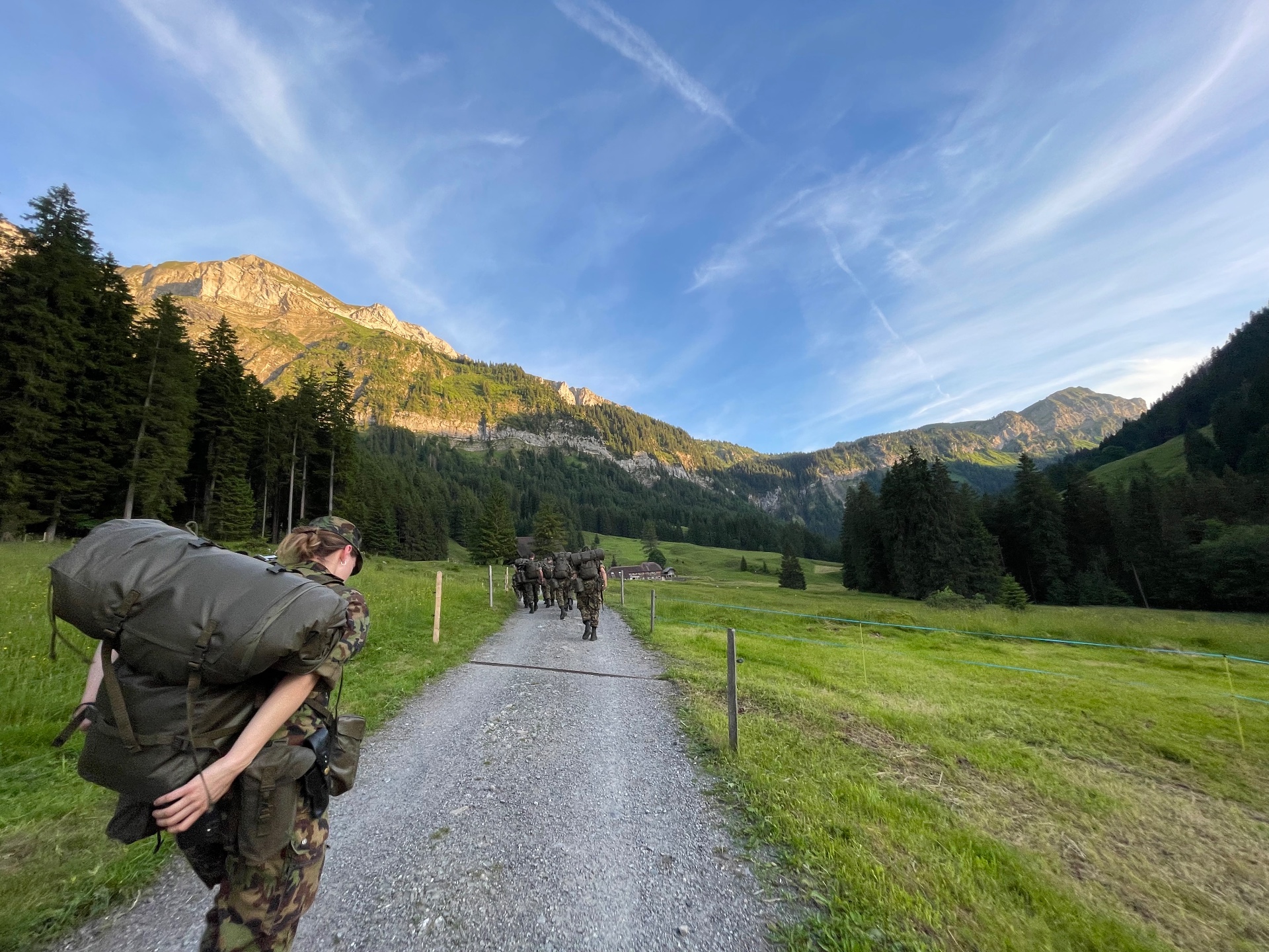 Militärangehörige auf einem Bergweg in alpiner Landschaft